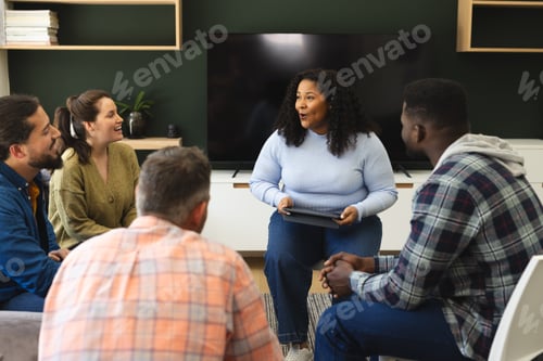 Preview: Diverse group of friends and female therapist with tablet in group therapy session