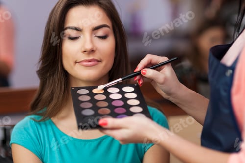 Preview: Beautiful female customer during the work of makeup artist