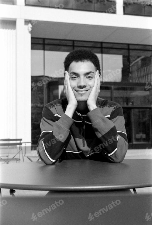 Preview: Young man posing with hands on face, grainy monochrome analog photography