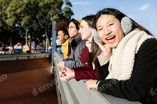 Preview: Young group of multi-ethnic friends enjoying sunset together in the city