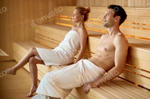 Preview: Smiling man day dreaming while relaxing in sauna at the spa.