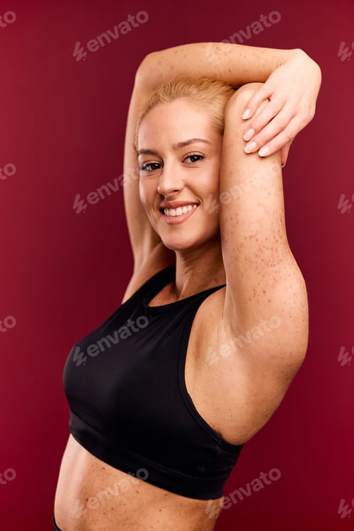 Preview: Portrait of a happy woman with spotted skin, dressed in a black sports set.