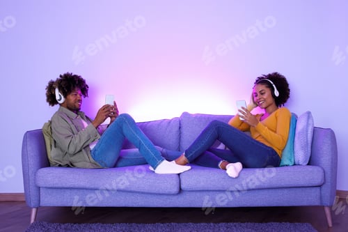 Preview: Black Young Spouses Wearing Headphones Listening To Music Together Indoor