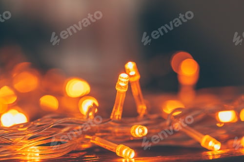 Preview: Warm light illuminated garland close up on dark background