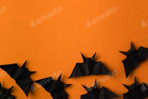 Preview: black origami bats for halloween, isolated on orange with copy space