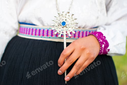 Preview: Traditional Saraguro women's silver jewelry in a woman's hand with a blue stone on its center