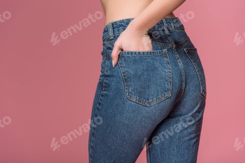 Preview: cropped view of female buttocks in jeans, isolated on pink