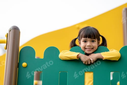 Preview: Asian little girl enjoys playing in a children playground, Outdoor portrait