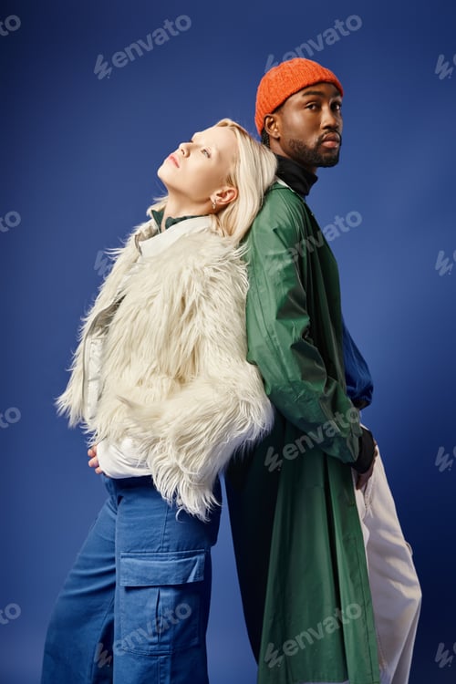 Preview: trendy interracial couple in winter attire, young woman in faux fur jacket and african american man