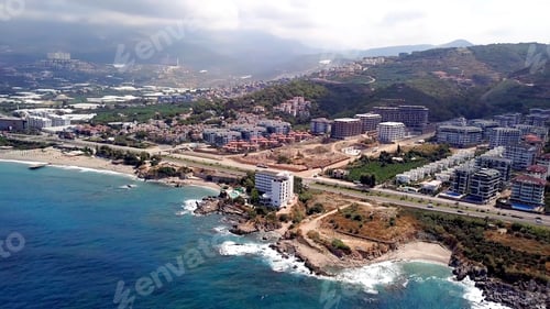 Preview: Top view of city located on mountain shore of blue sea. Stock footage. Beautiful landscape of modern