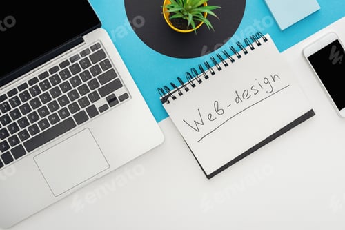 Preview: top view of laptop, smartphone, plant, notebook with web design lettering on abstract geometric