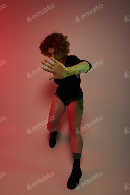 Preview: Fiery Spirals: A Redheaded Woman Twirls in Front of Crimson Glow