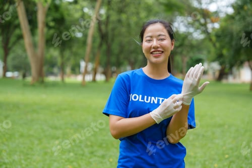 Preview: Young volunteer wearing gloves getting ready for volunteering in park
