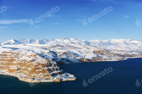 Preview: Amazing winter landscape of Charvak reservoir with blue water in Uzbekistan on a winter day