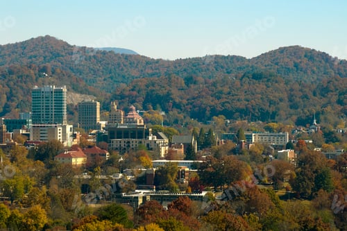 Preview: Aerial view of Asheville city in North Carolina with high buildings and mountain hills in distance