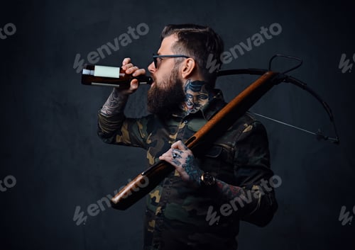 Preview: A man holds the craft beer bottle and a crossbow.
