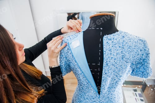Preview: Female seamstress prepares dress to the fitting and takes measurements.