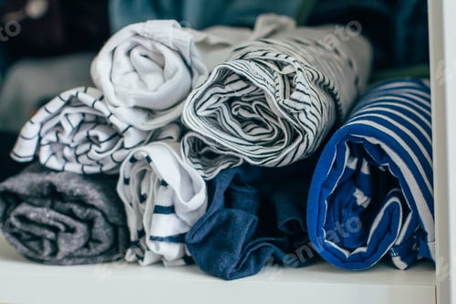 Preview: Marie Kondo tyding up method concept - folded clothes. White, gray, blue and striped T-shirts