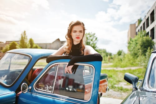 Preview: Girl model with bright makeup in retro style in vintage car