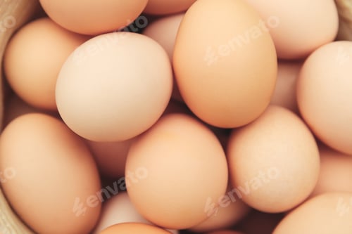 Preview: eggs in straw hat on grass background. Chicken eggs in wooden basket on green nature floor at cloudy