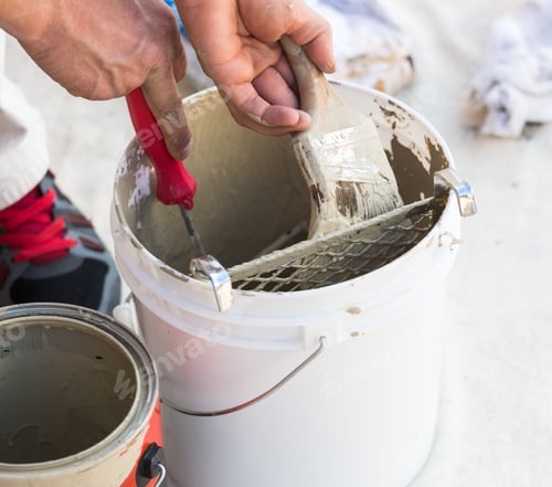 Preview: Professional Painter Loading Paint Onto His Brush From A Bucket.
