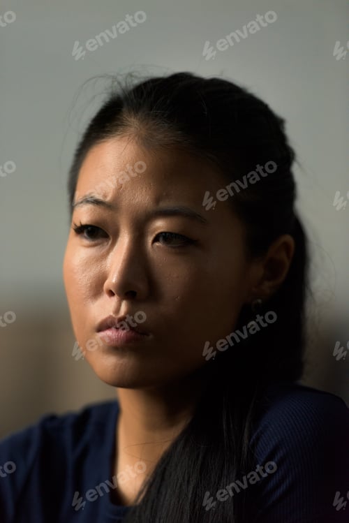 Preview: Close-up portrait of beautiful rebel Asian woman face looking sad and serious outdoors