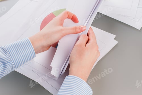 Preview: Female hands working with charts and diagrams.
