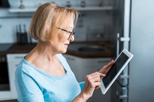 senior woman using digital tablet at home