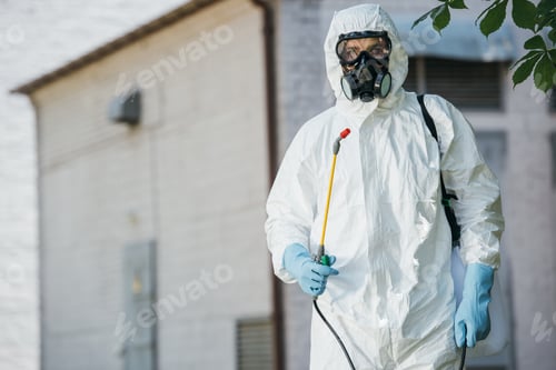 Preview: pest control worker in respirator holding sprayer