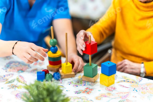 Preview: Nurse assisting elderly woman playing with colorful wooden toys