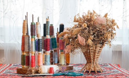 Preview: Sewing multicolored threads of soft pastel vintage colors on spools.