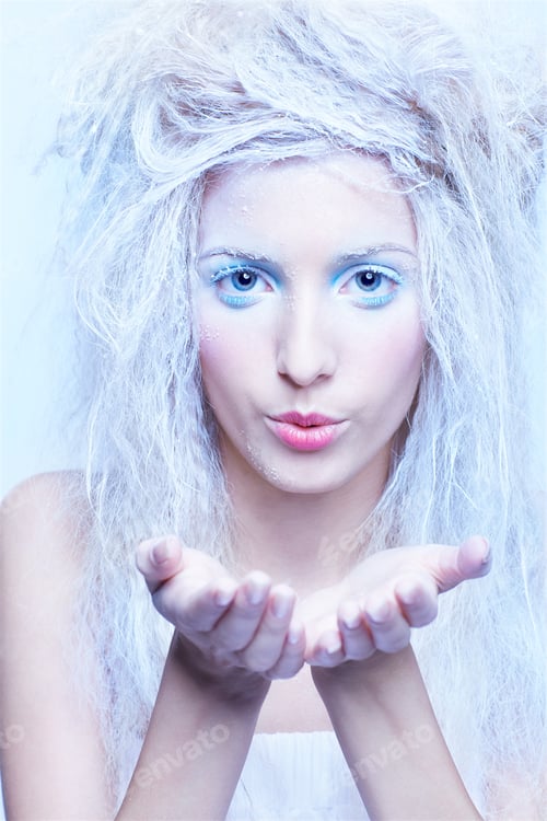 Preview: Portrait Of Beautiful Blonde Frozen Fairy Girl Blowing Snow Flakes From Hands