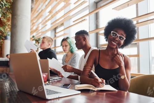Preview: Black woman sitting in front of group of multi ethnic people with alternative girl with green hair