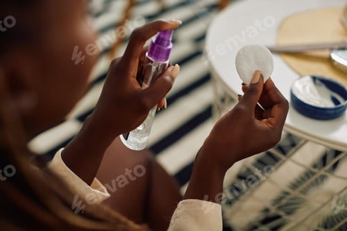Preview: Close-up of African American woman taking care of her face skin at home.