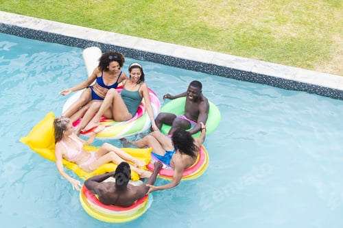 Preview: Diverse group of friends enjoy a pool party on colorful floaties