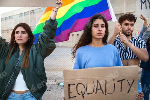 Preview: People march together protesting for LGBT rights holding cardboard banners and waving rainbow flag.