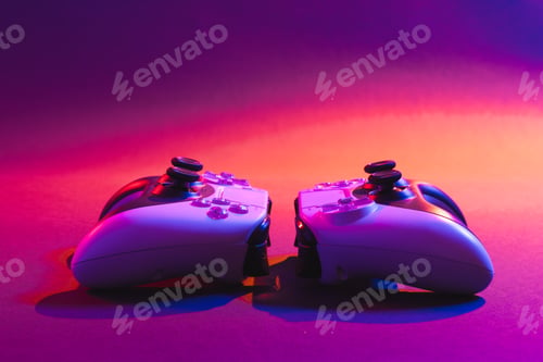 Preview: Composite of video game pads and copy space on neon background