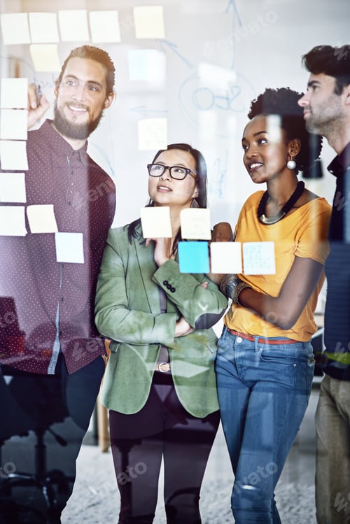 Preview: Cropped shot of a group of businesspeople working on a glass wall the office