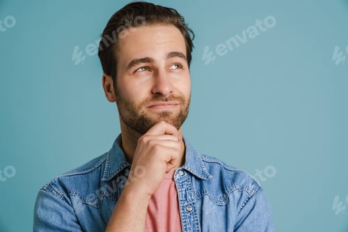 Preview: Young puzzled man wearing shirt smiling and looking aside