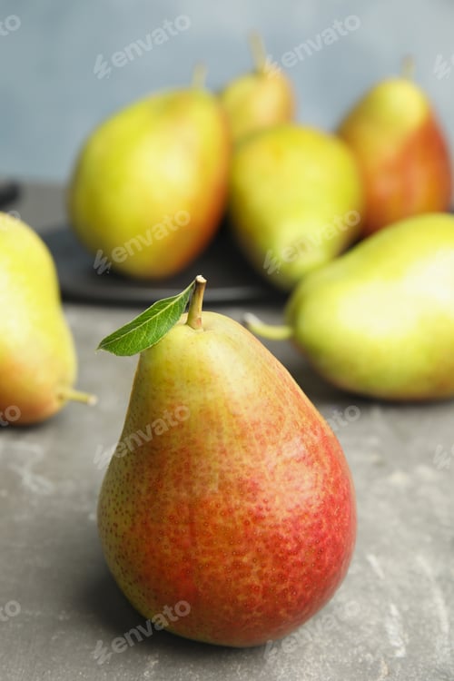 Preview: Ripe juicy pears on grey stone table against blue background
