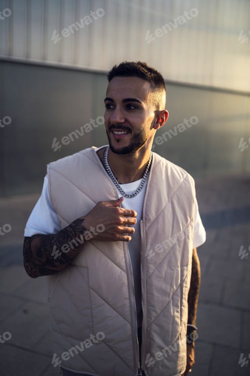 Preview: Vertical shot of a sexy European man with tattoos in the streets in Spain