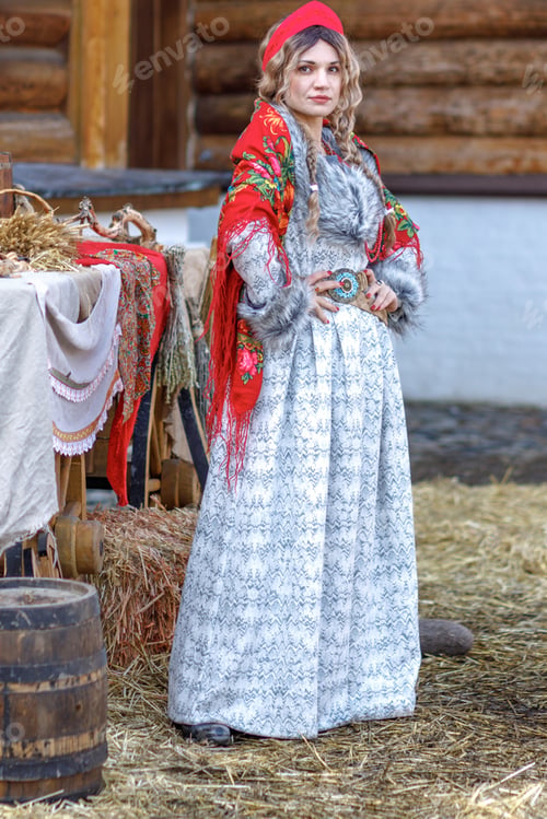 Preview: A girl in traditional Russian clothes and a kokoshnik stands at a table with various national dishes
