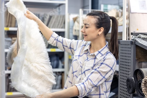 Preview: A young woman chooses goods for a home interior in a store.