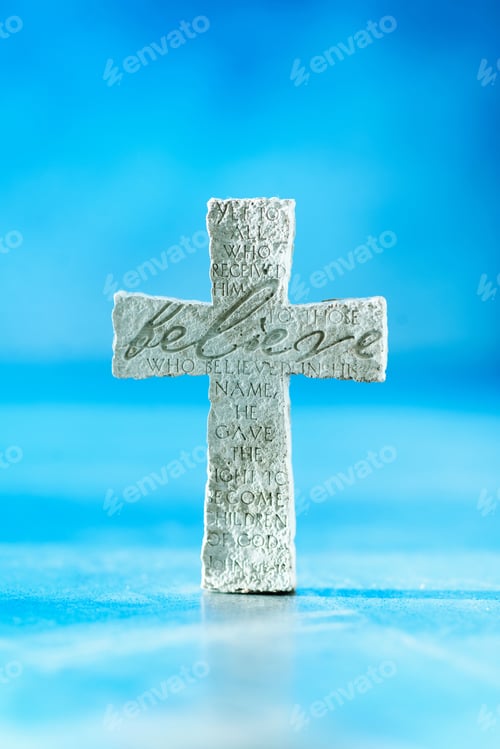 Preview: Stone cross with inscription Believe on blue background, Copy space. Christian backdrop. Biblical