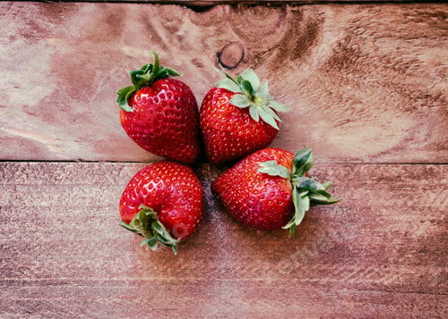 Preview: Four Fresh Strawberries Arranged on a Wooden Surface