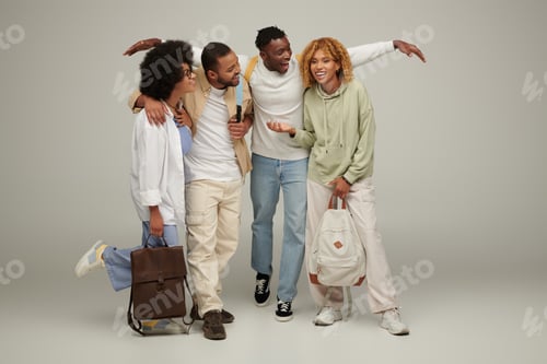 Preview: young stylish friends in casual wear with backpacks talking lively and smiling cheerfully, students