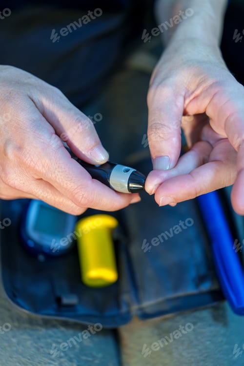 Preview: Woman using a lancing device to measure blood glucose levels, with glucose meter