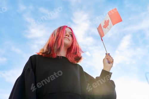 Preview: Student girl teenager with Canada flag in hand, blue sky with clouds background.