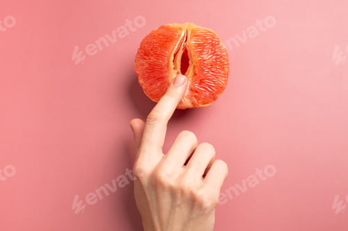 Vorschau: Eine Frau hält eine Grapefruit an ihrem Höschen. Konzept Masturbation