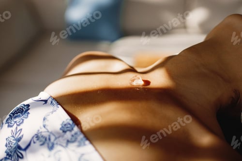 Preview: Cropped hoto of ice cube on the girl's body in swimwear